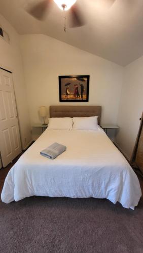 a bedroom with a white bed with a picture on the wall at Unit 5 - Stay at Roosevelt Row Modern 2BR 2BA Condo in Phoenix