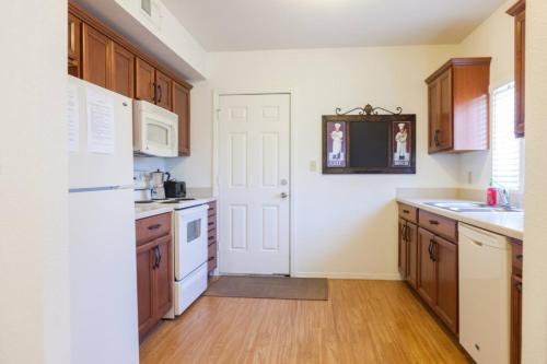 a kitchen with wooden cabinets and a white refrigerator at Unit 5 - Stay at Roosevelt Row Modern 2BR 2BA Condo in Phoenix