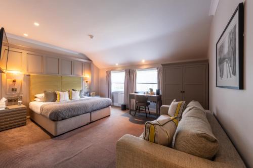 une chambre d'hôtel avec un lit et un canapé dans l'établissement The Royal Wells Hotel, à Royal Tunbridge Wells