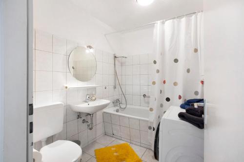 a bathroom with a sink and a toilet and a bath tub at Stadtappartement Sievers in Weil am Rhein