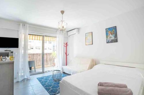 - une chambre blanche avec un lit et un salon dans l'établissement Idéalement situé studio éco-responsable classé 3*, à Roquebrune-Cap-Martin