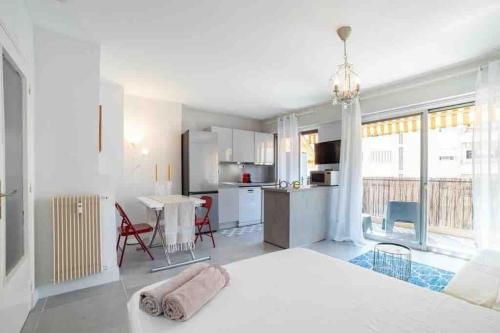 une grande chambre blanche avec un grand lit et une cuisine dans l'établissement Idéalement situé studio éco-responsable classé 3*, à Roquebrune-Cap-Martin