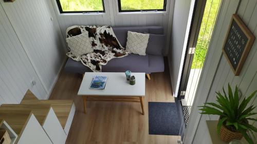 an overhead view of a living room with a couch and a table at Taranaki Creekside TUI by Tiny Away in Stratford