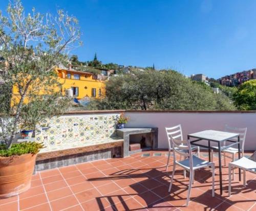 a patio with chairs and a table and a fireplace at Casita Max Unique and great location in San Miguel de Allende