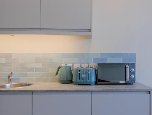 a kitchen counter with a sink and a microwave at GuestReady - Dublin 8 Delight Retreat in Dublin