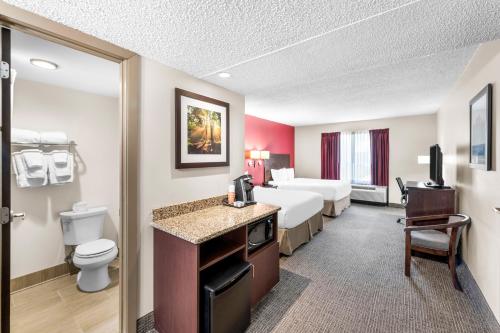 a hotel room with two beds and a bathroom at Quality Inn in Columbus