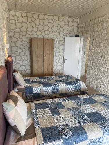 a bedroom with two beds and a wall at Hamre Apartments (Nicholas) in Agios Georgios Pagon