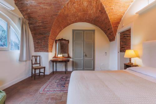 a bedroom with a bed and a brick wall at Hotel Villa Sermolli in Borgo a Buggiano