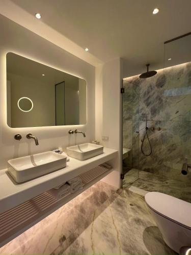 a bathroom with a sink and a shower at Nomia Sunset Suites Mykonos in Tagou