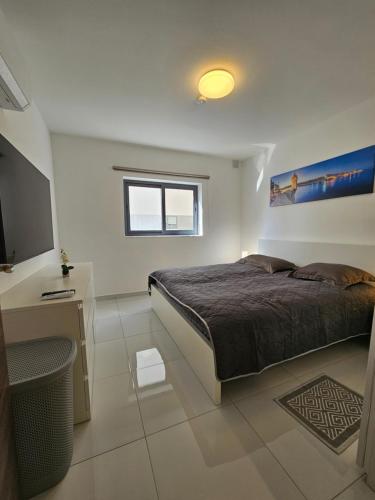 a bedroom with a bed and a flat screen tv at Family holidays in St. Paul's Bay