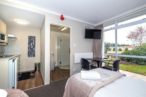 a room with a bed and a table and a kitchen at Methven Nest Apartment in Methven