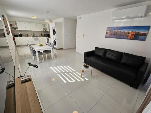 a living room with a black couch and a table at Family holidays in St. Paul's Bay