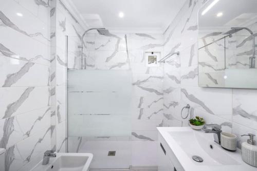 アルマンシルにあるStunning 2-Bedroom Beach Retreat in Vale do Loboのシャワーと洗面台を備えた白いバスルーム
