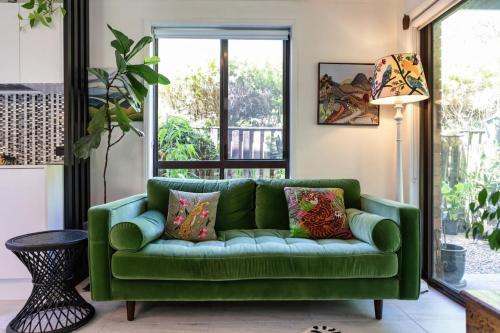 a green couch in a living room with a window at Riverfront Oasis in Elanora in Gold Coast