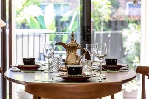 a table with a tea kettle and glasses on it at Riverfront Oasis in Elanora in Gold Coast