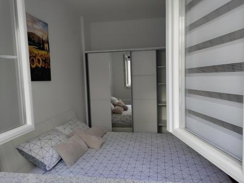a small bedroom with a bed and a mirror at Nevena in Trebinje