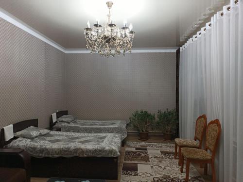 Zimmer mit einem Bett und einem Kronleuchter in der Unterkunft Oskar in Toktogul