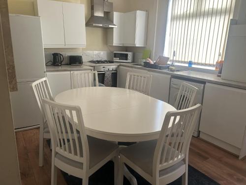 曼徹斯特的住宿－Manchester Levenshulme Entire house Sleeps 7Max，白色的厨房配有白色的桌子和椅子