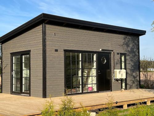 a small black building with a basketball hoop at Attefallare i äppelriket in Vånga