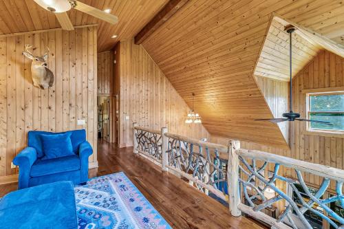 a living room with a blue chair and wooden walls at Mountain Views and Deck Stunning Sapphire Cabin in Sapphire