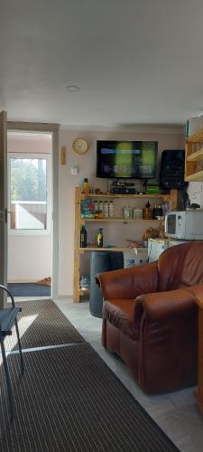 een woonkamer met een bank en een flatscreen-tv bij Pirts,kubls,,Saknēs,, in Talsi