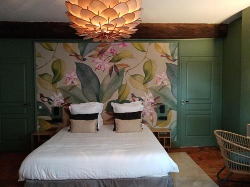 a bedroom with a bed with a flower wallpaper at Art'Hotel & SPA Le Potin Gourmand in Cluny