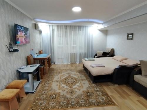 1 dormitorio con cama, sofá y mesa en Cozy apartment "Sam House", en Tashkent
