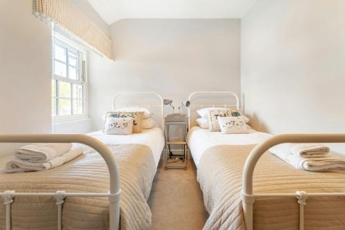 Habitación con 2 camas individuales y paredes blancas. en Apple Tree Cottage, en Ambleside