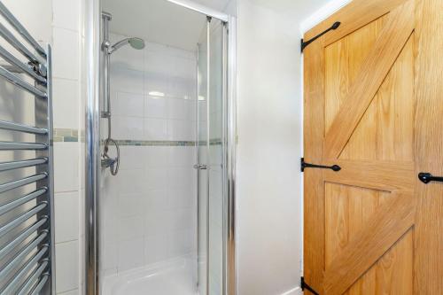 baño con ducha y puerta de cristal en Apple Tree Cottage, en Ambleside