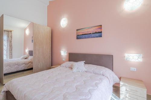 ein Schlafzimmer mit einem großen Bett und einem Spiegel in der Unterkunft Casa Iole Portopalo in Portopalo