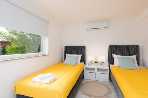 two twin beds in a room with a window at Apartman Grey in Slunj