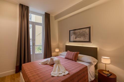 a bedroom with a bed and a window at Piazza San Domenico Luxury Suites in Naples