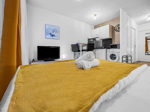 a bedroom with a large bed with a yellow blanket at Studio enchanté avec terrasse in Luce
