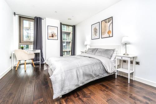 Stunning 2 Bedroom Apartment in Tower Hill في لندن: غرفة نوم بيضاء مع سرير ومكتب