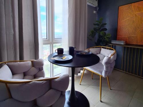 馬尼拉的住宿－ELUDE Designer Suite Pasig - Prime Location，一间带桌子和两把椅子的用餐室