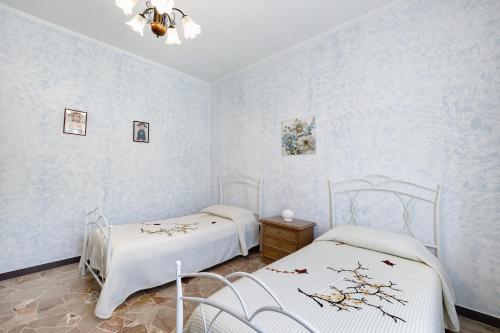two beds in a room with blue walls at Casa Grace - Casa al Mare in Vado Ligure