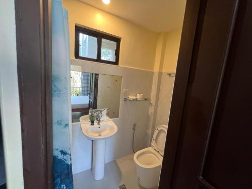 a bathroom with a sink and a toilet at Adayo Cove Resort in Siquijor