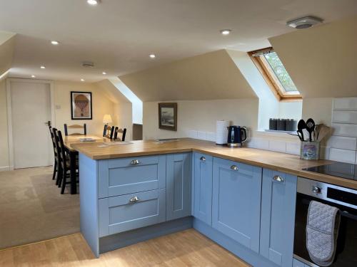 a kitchen with blue cabinets and a counter top at Garbity Cottage in Fochabers