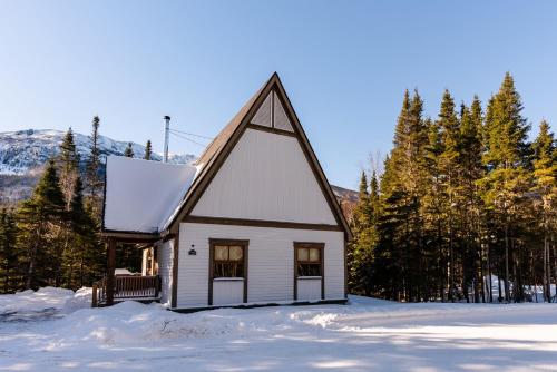 a small house with a triangular roof in the snow at Gîte du Mont-Albert - Sepaq in Sainte-Anne-des-Monts