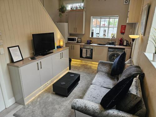 a living room with a couch and a kitchen at Carlisle Central, Cute Studio Appt, The Cupboard in Carlisle