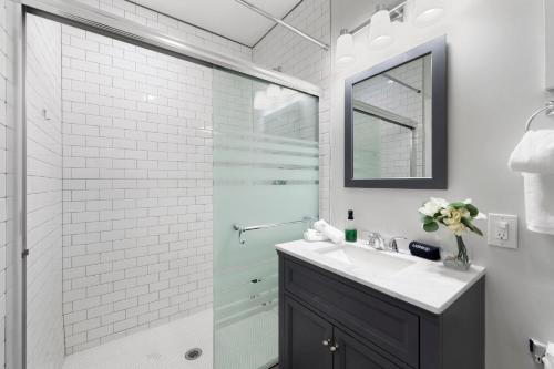 a bathroom with a shower and a sink and a mirror at Chicago Treasure 4 Bed Getaway in Chicago
