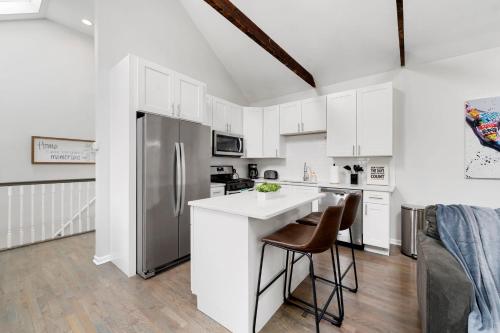a kitchen with white cabinets and a stainless steel refrigerator at Chicago Treasure 4 Bed Getaway in Chicago