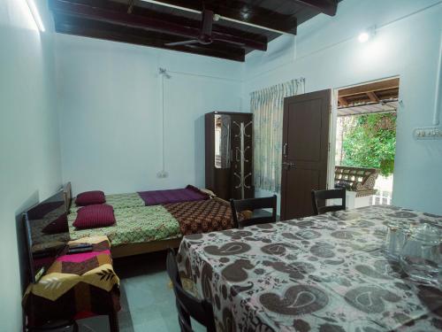 a bedroom with two beds and a table and chairs at Sanctuary View Homestay Thattekad in Ernakulam