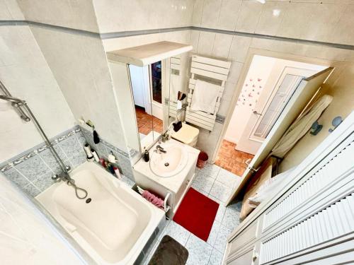 une salle de bain avec une baignoire, un lavabo et des toilettes dans l'établissement Sweet Home 1mn Train RER A et 10mn de Paris, à Houilles