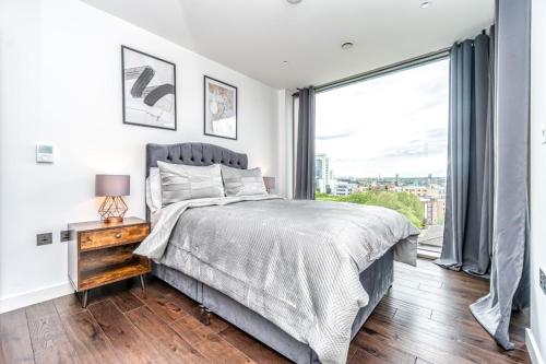 a bedroom with a bed and a large window at Luxury 2 Bedroom Apartment in Tower Hill in London