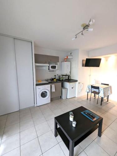 un salon avec une table et une cuisine dans l'établissement Maubec YourHostHelper, à Bayonne