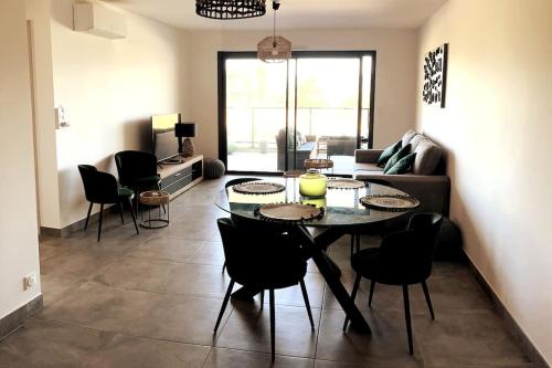 un salon avec une table et des chaises dans l'établissement Appartement avec terrasse 3 pièces - Vue mer - Plage 5 min à pied, à Propriano