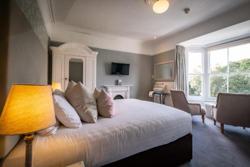 a bedroom with a bed with a lamp and a window at Ambleside Townhouse in Ambleside