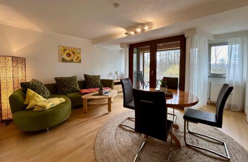 ein Wohnzimmer mit einem grünen Sofa und einem Tisch in der Unterkunft Ferienwohnungen an der Hufeland-Therme in Bad Pyrmont