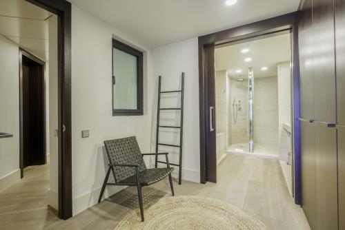 um quarto com uma cadeira e uma cabina de duche ao nível do chão em Ola Living Paseo de Gracia em Barcelona